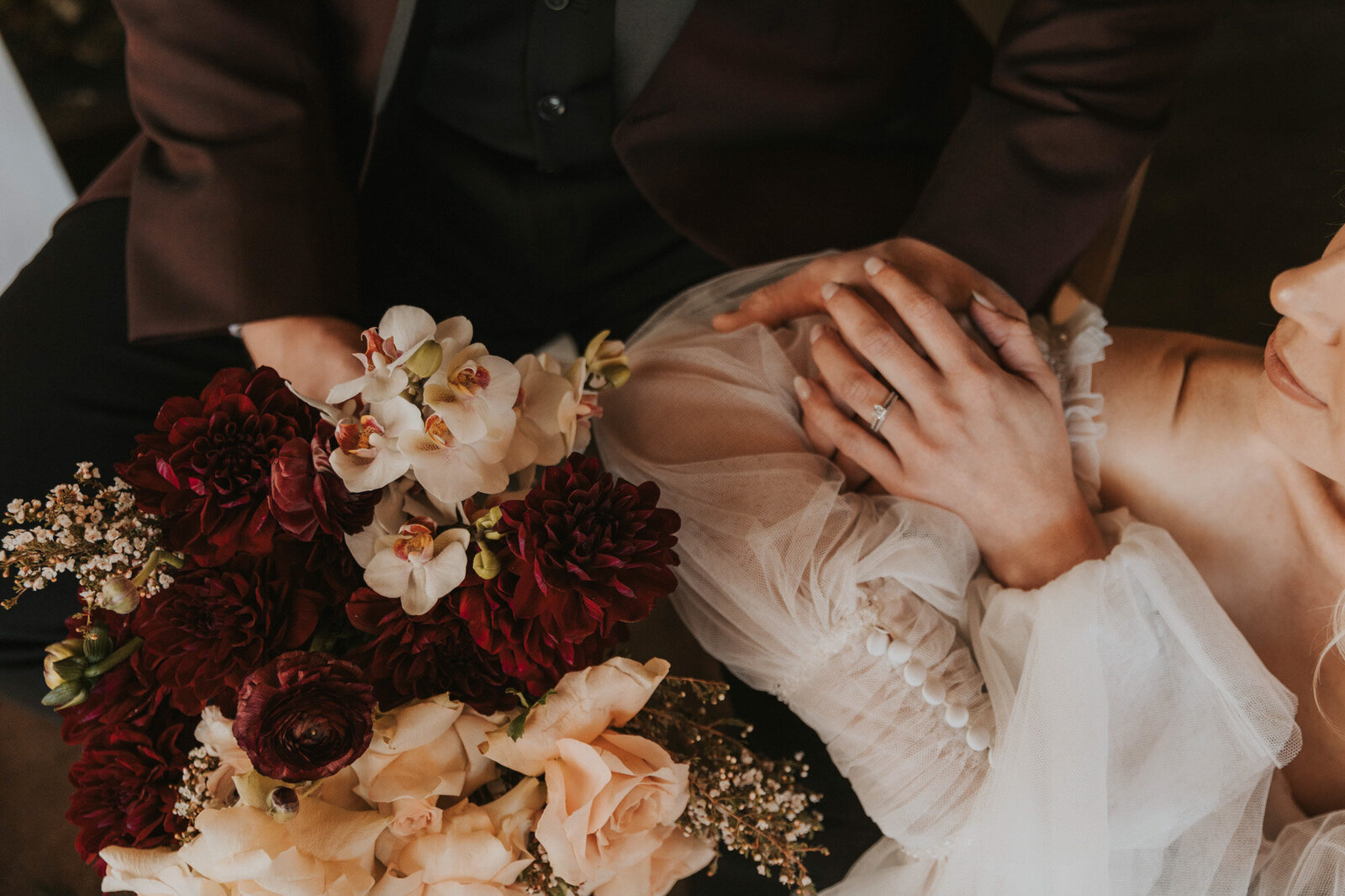 Bride and groom holding each others hand with their colorful floral bouquet