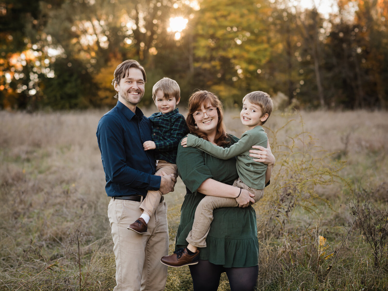 parents holding two sons for family photos at sunset in park Cleveland family photography