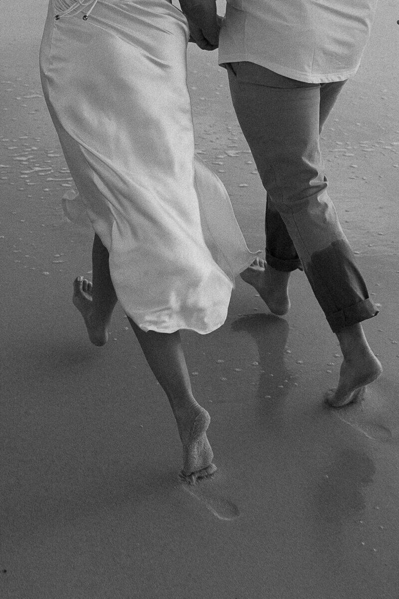 couple running on beach for engagement photography session in naples fl