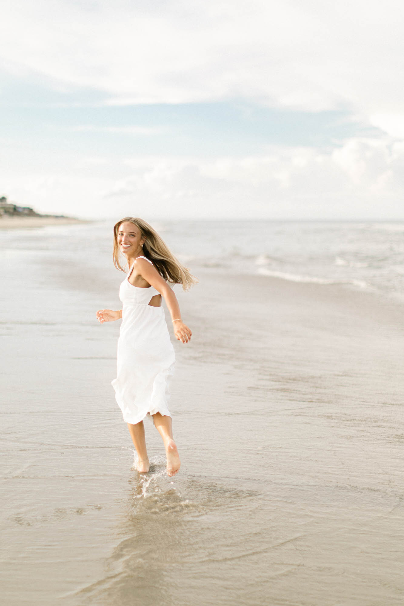 A senior photo of the girl running on the beach of the OBX