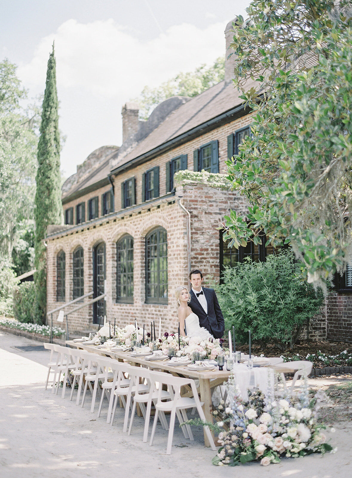 Bride and groom by reception table behind Middleton Place. Photographed by wedding photographers in Charleston Amy Mulder Photography