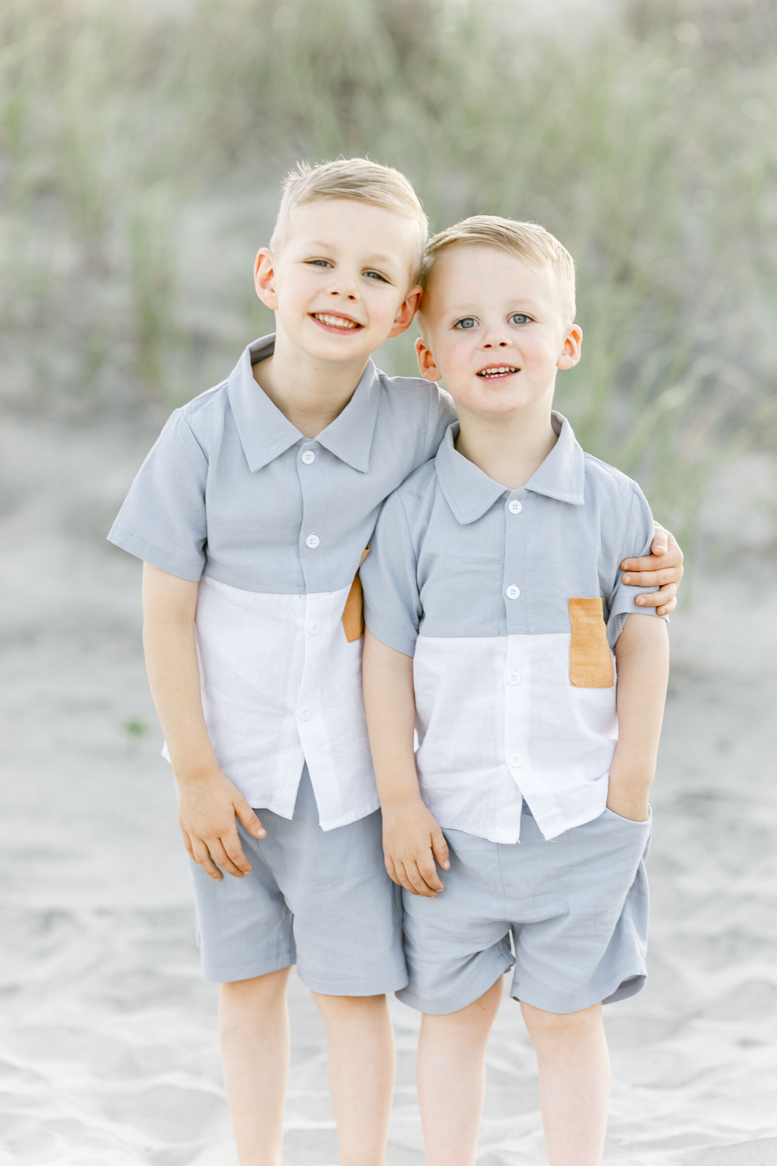 brother standing next to each other on ocean city beach photographed by ally kimpton photography