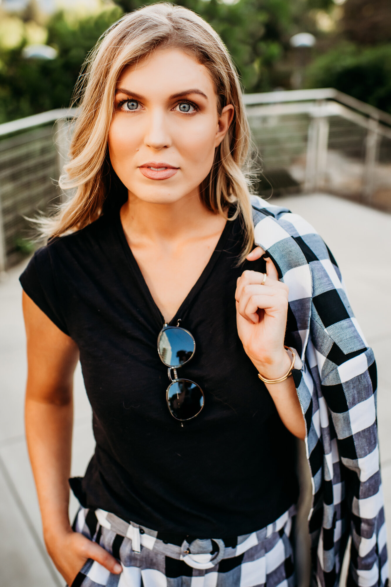 Branding Photographer, a woman wears a v-neck shirt flannel pants and holds flannel jacked outside