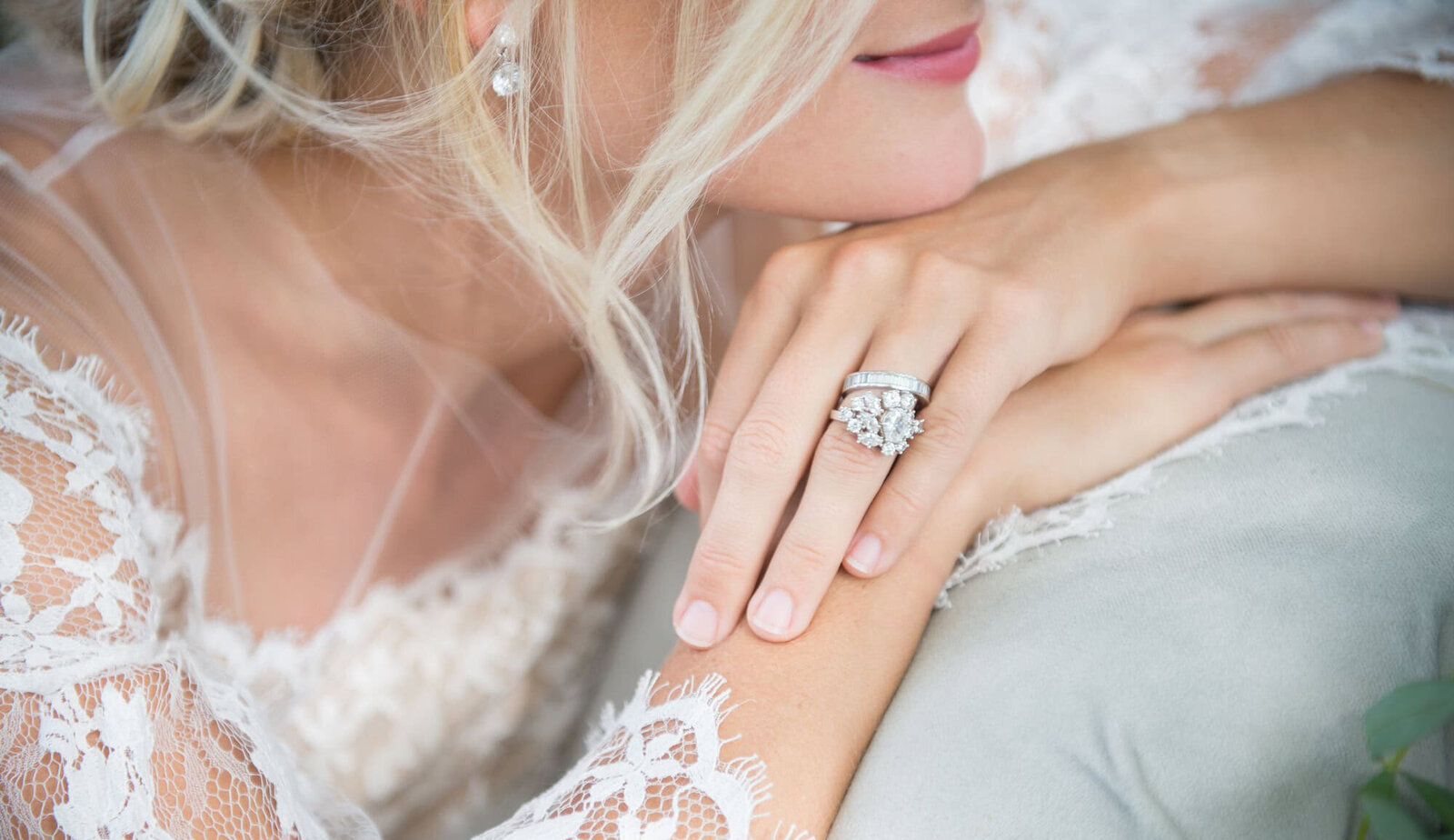 bride rests chin on hands with focus on diamond ring