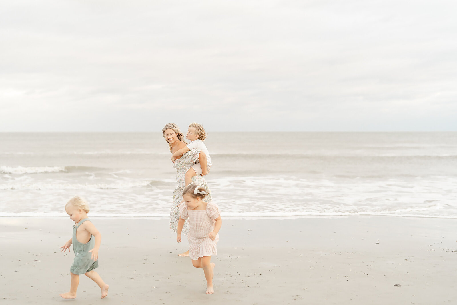mom and kids running at the beach taken by a Northern Virginia family photographer