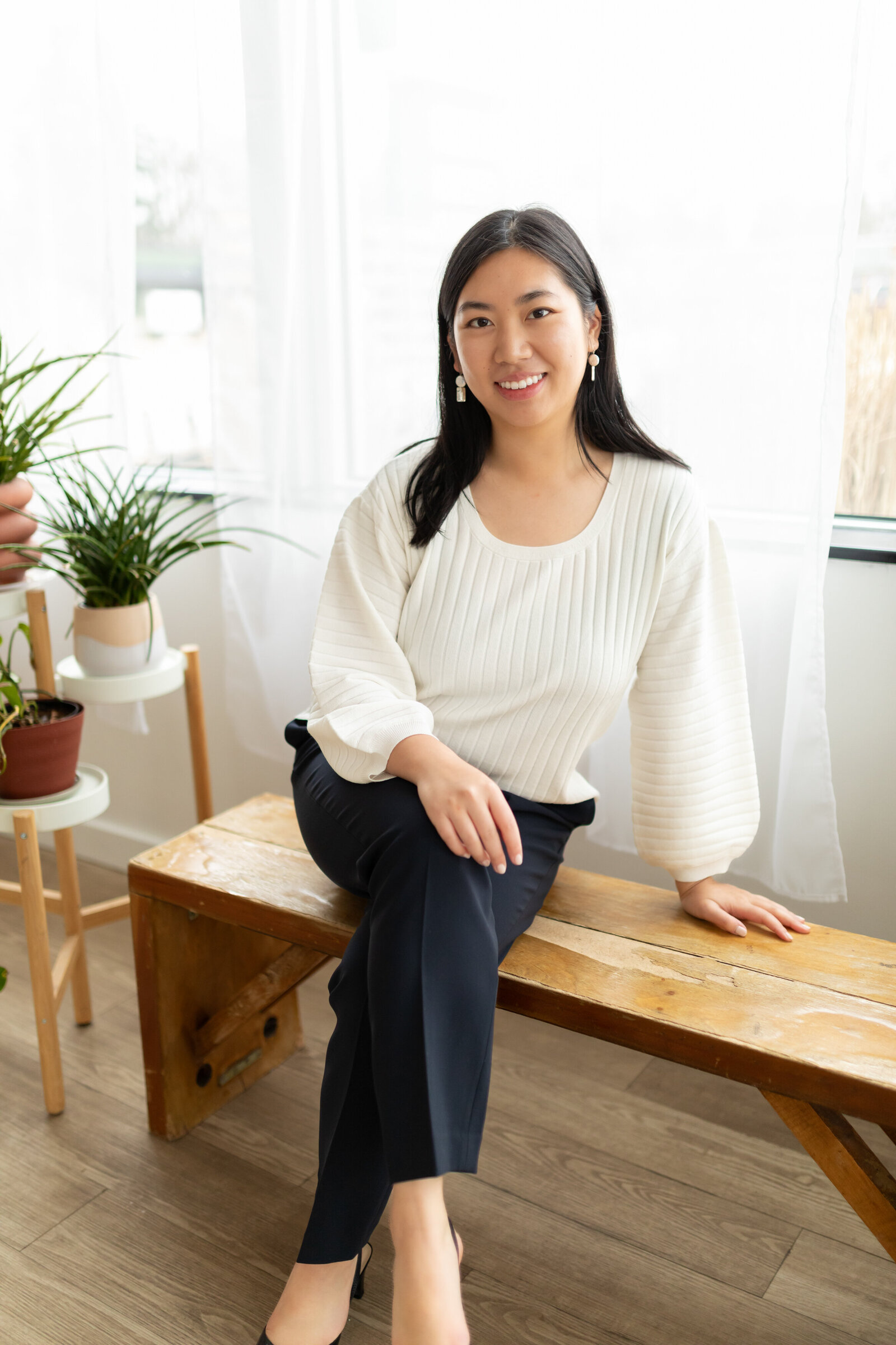 woman sitting on bench leaning and smiling at camera