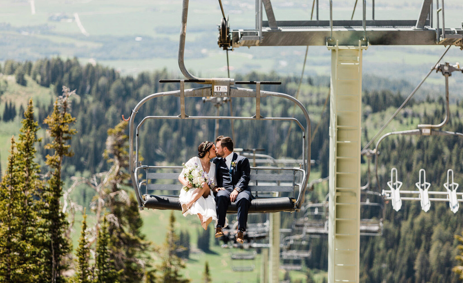 A couple rides a charilift after their mountaintop elopement at Grand Targhee photographed by Washington elopement photographer Amy Galbraith