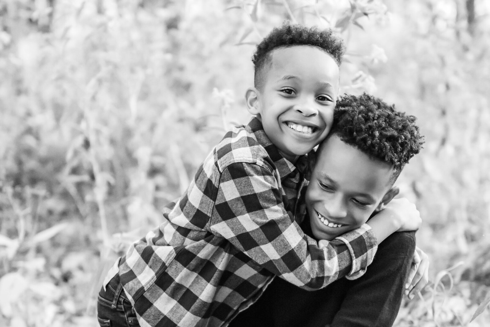 black and white photo of two young brothers hugging