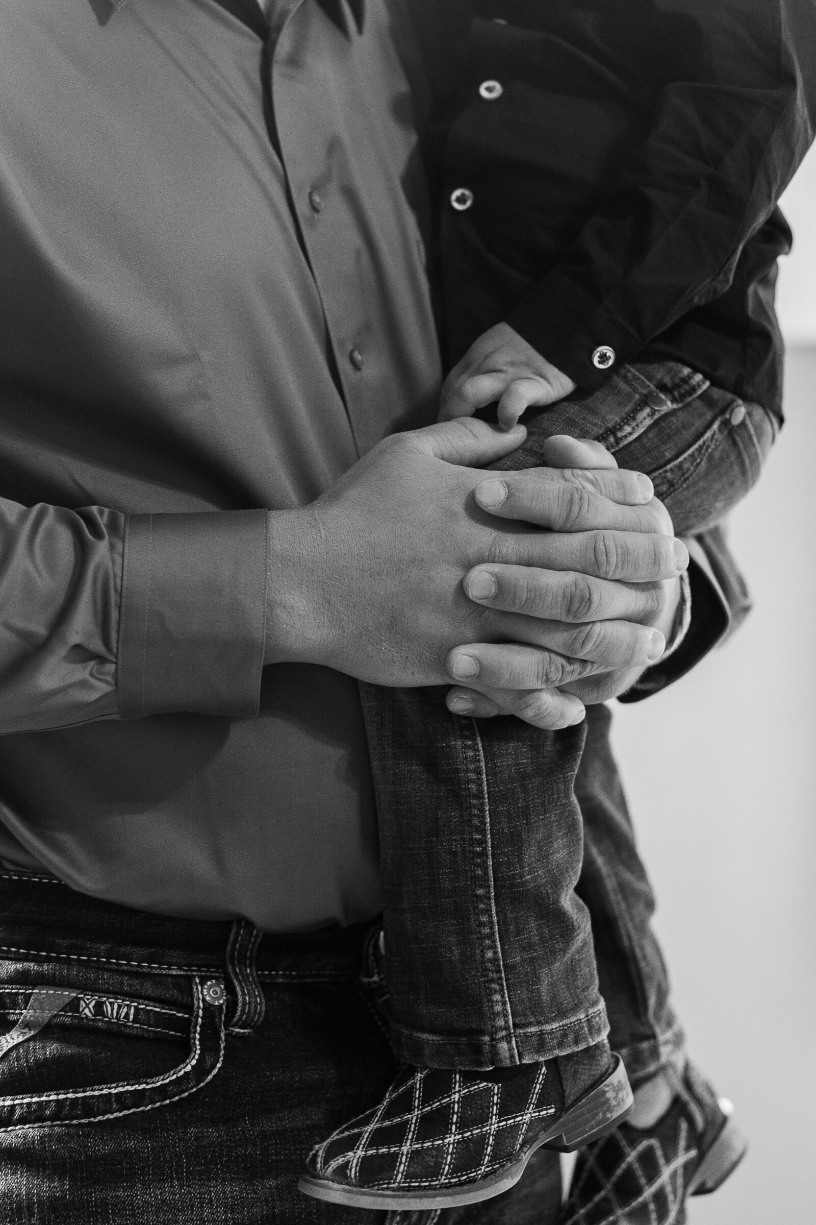 Close up image of grooms hands as he holds his little son before his wedding at Arrowhead, Colorado