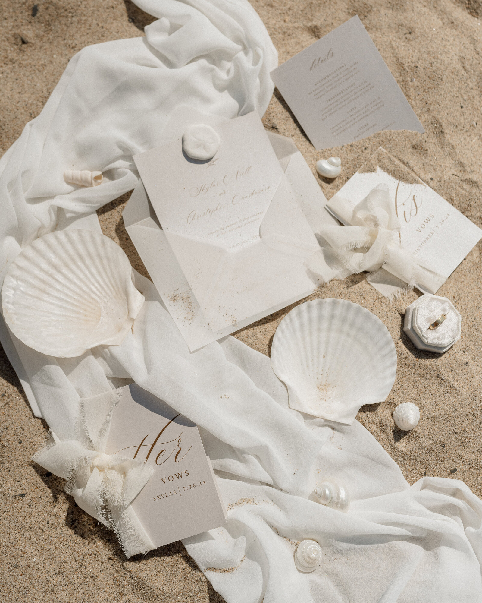 wedding detail photo of vow book and seashells during socal wedding
