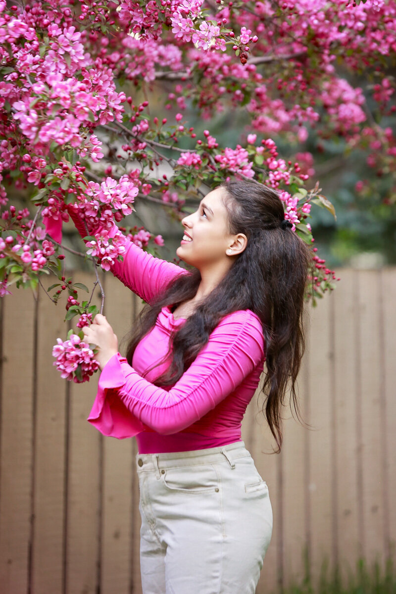 Girl wearing pink portrait in pink crab apple in Calgary by Yuliia Terziian Photography.