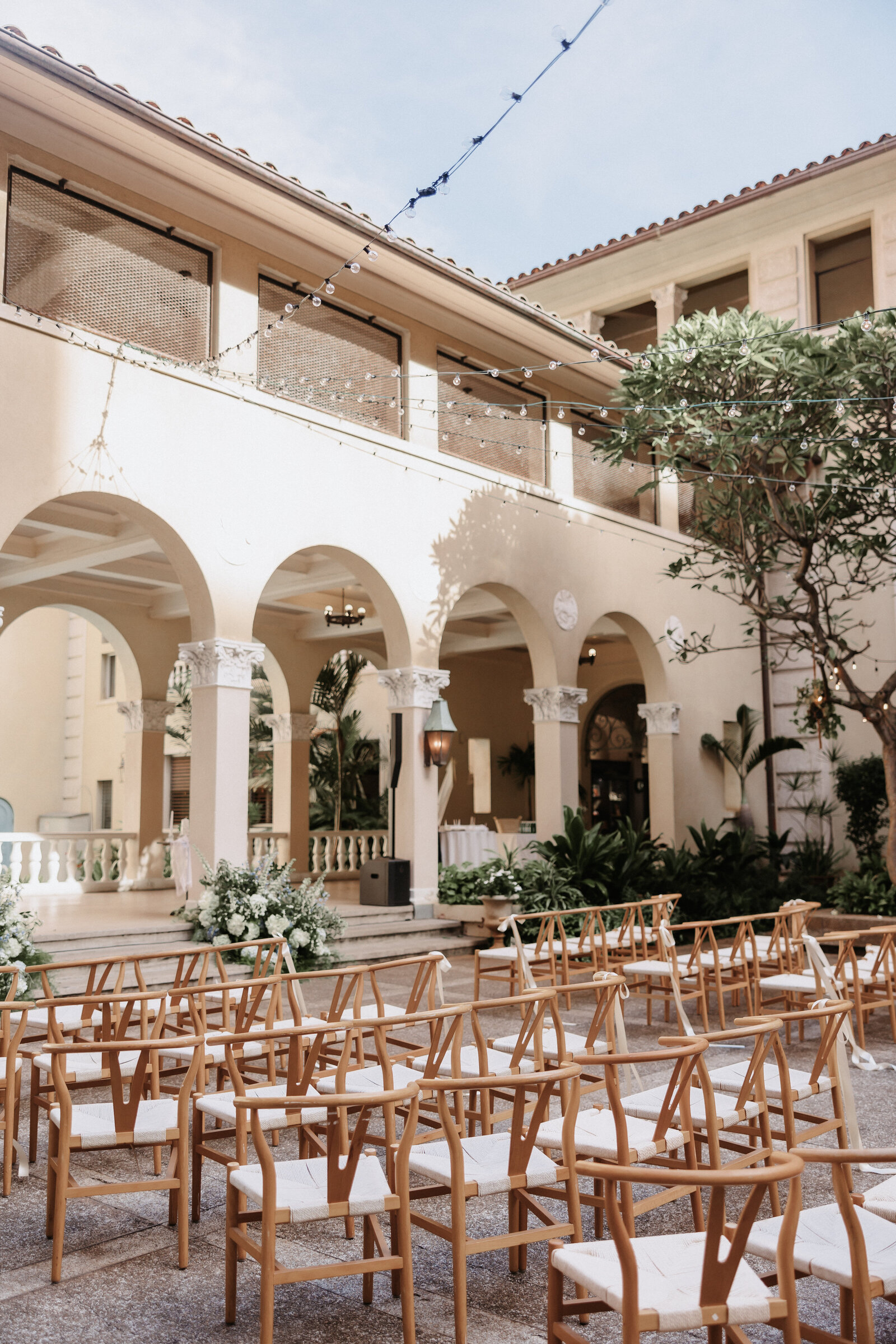 Ceremony set up at cafe julia hawaii wedding with wishbone chairs