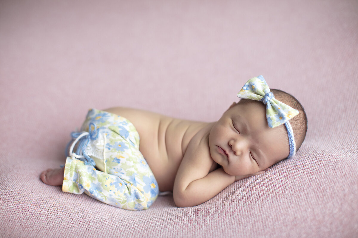 Newborn girl in colorful outfit, a Dallas newborn photogrpaehr.