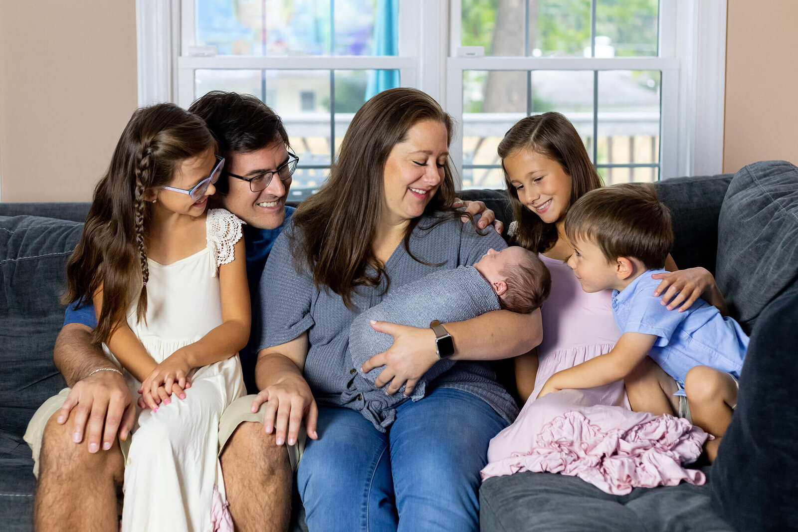 A family of six sitting on the couch for their session with Northern Virginia newborn photographer, Melissa Driggers.