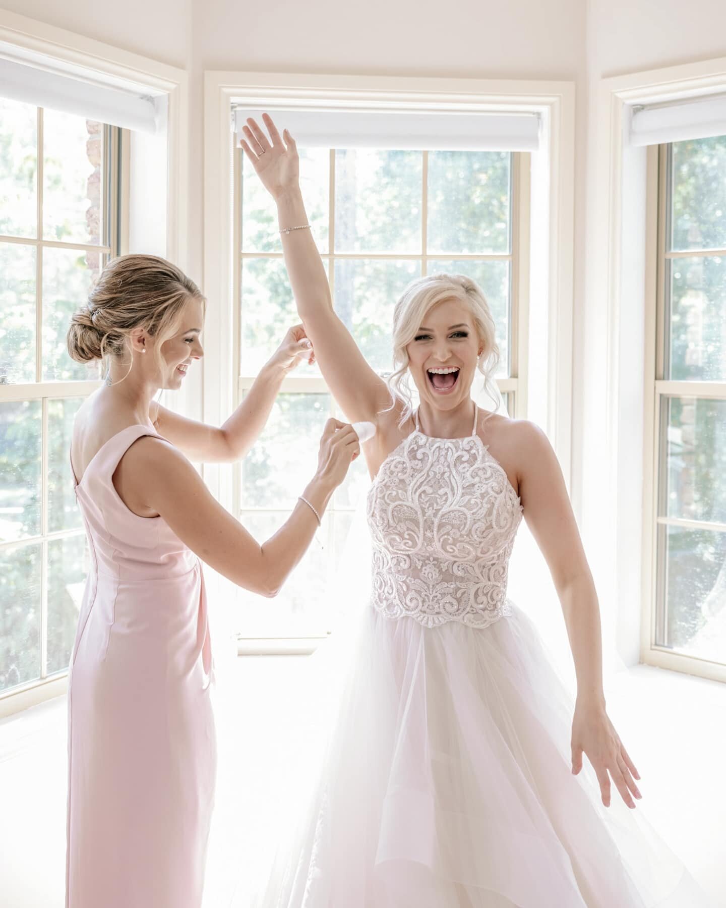 bridesmaid applying deodorant to aBride in Oksana Mukha wedding gown