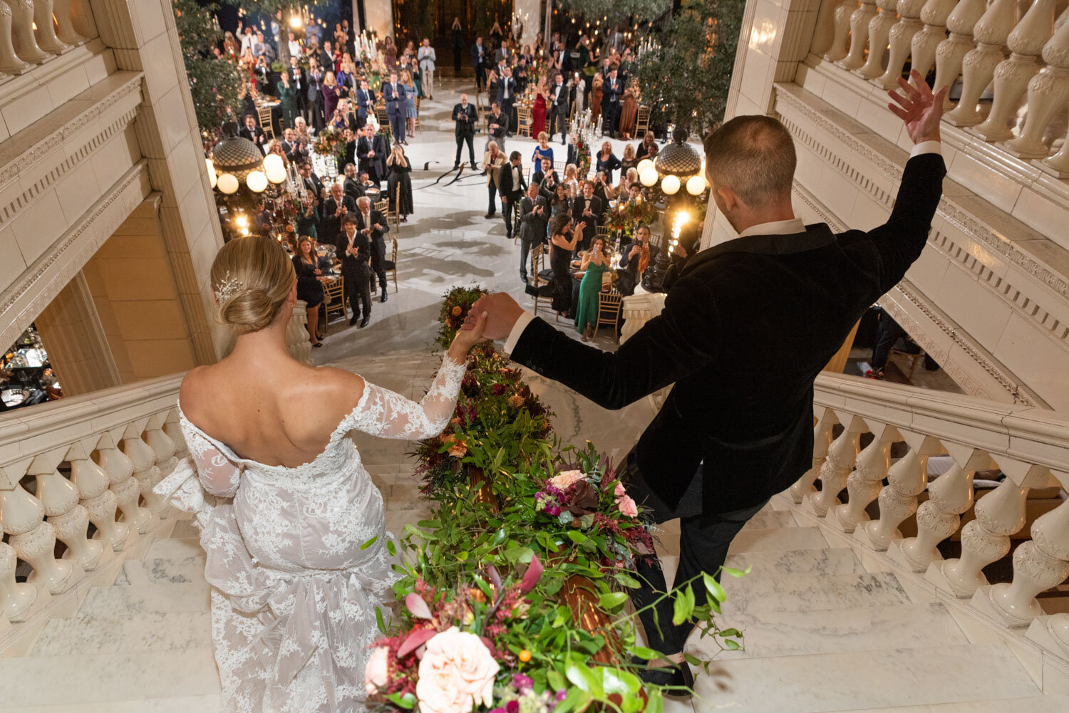 A bride and groom are standing in front of a crowd of people
