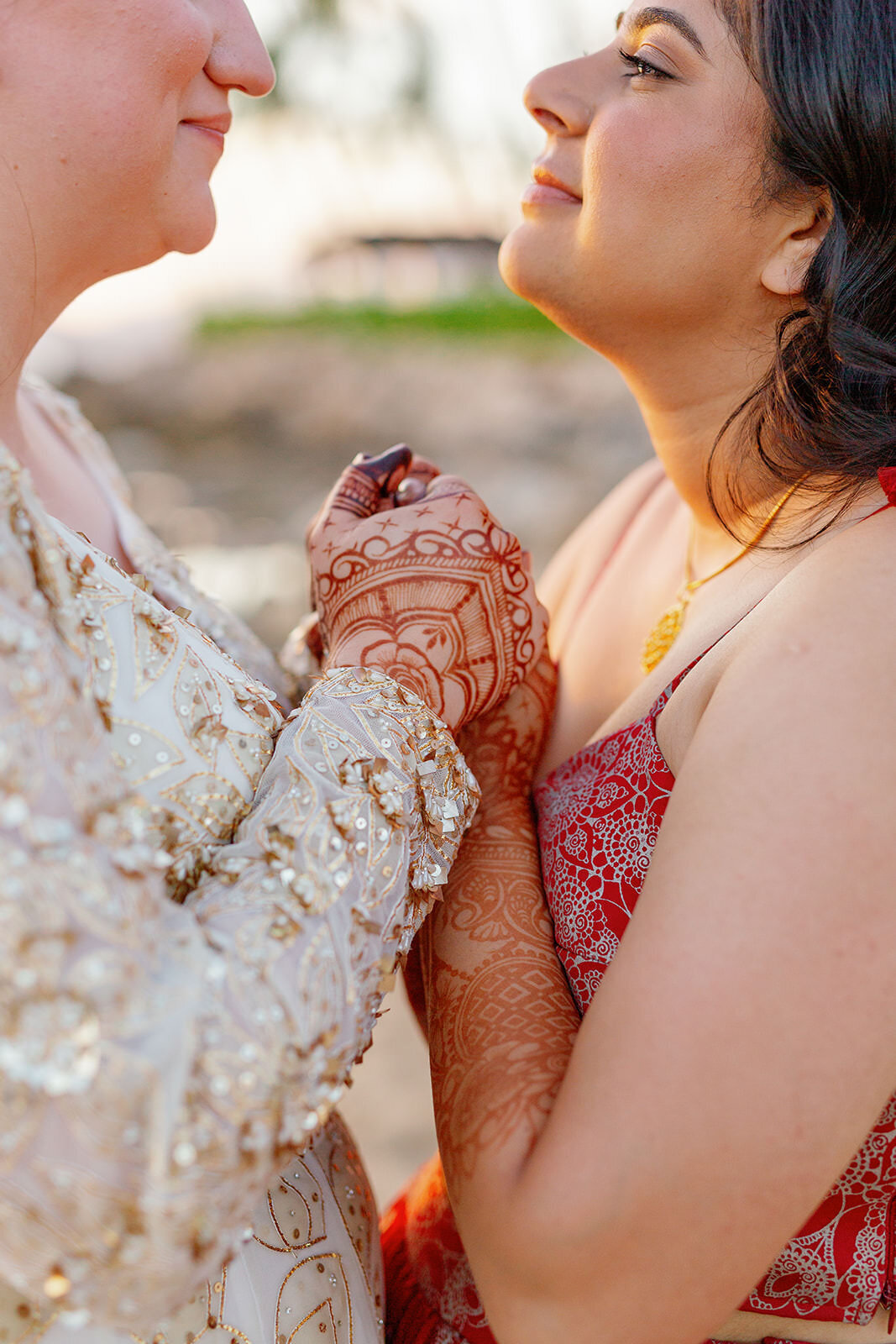 A close up view of a newlywed couple holding hands in between each other 