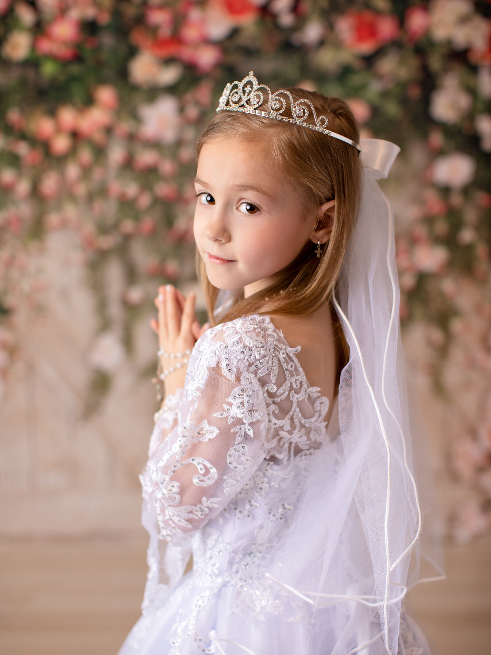 first communion photoshoot with floral backdrop