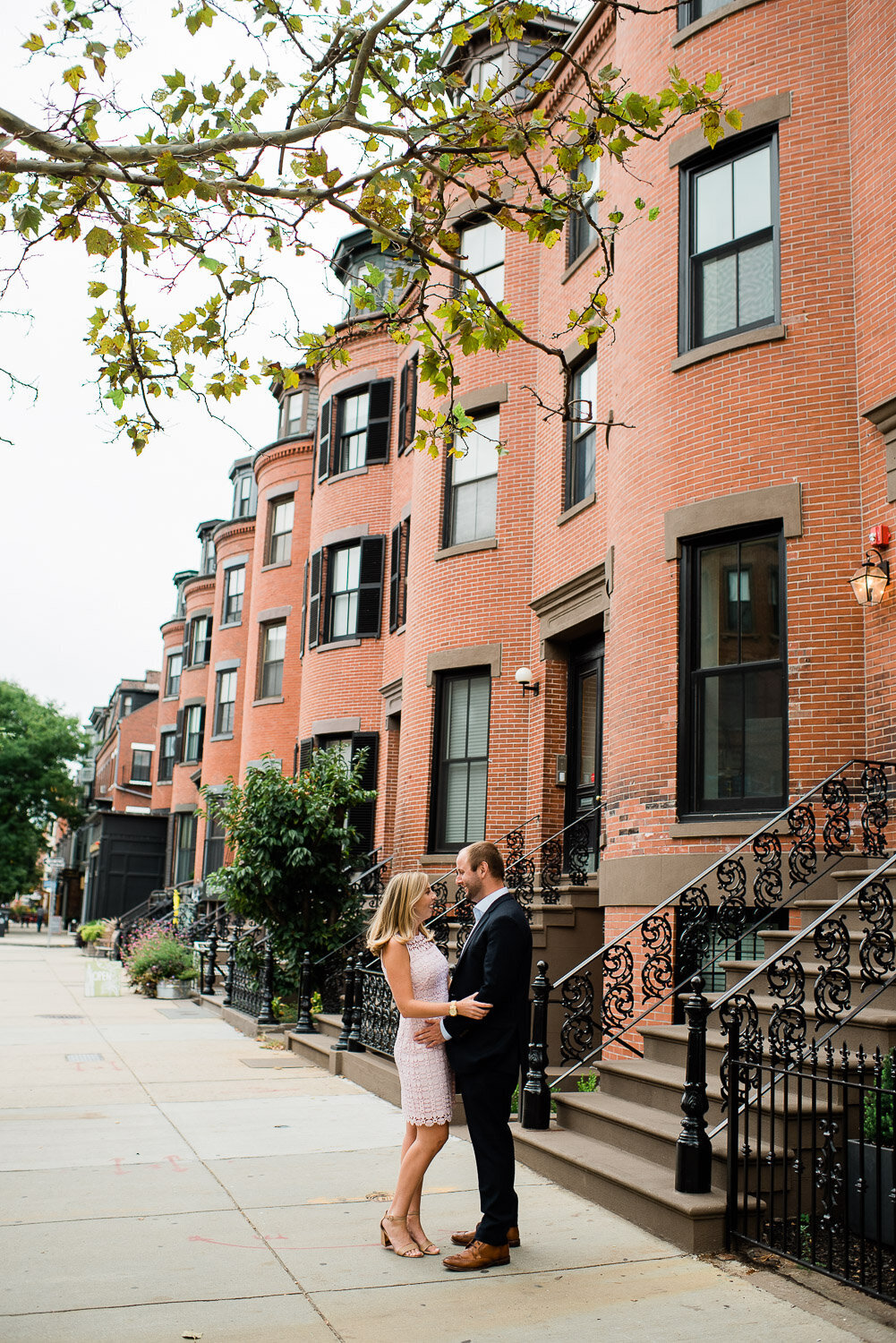 couple facing each other in front of Boston  brownstone