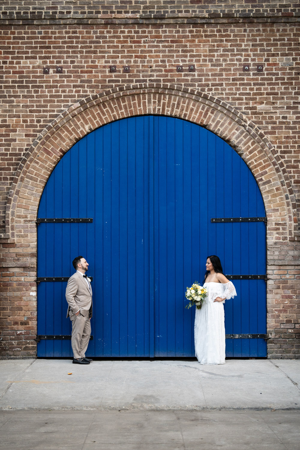 Bride and groom in front of large blue door in Downtown New Orleans