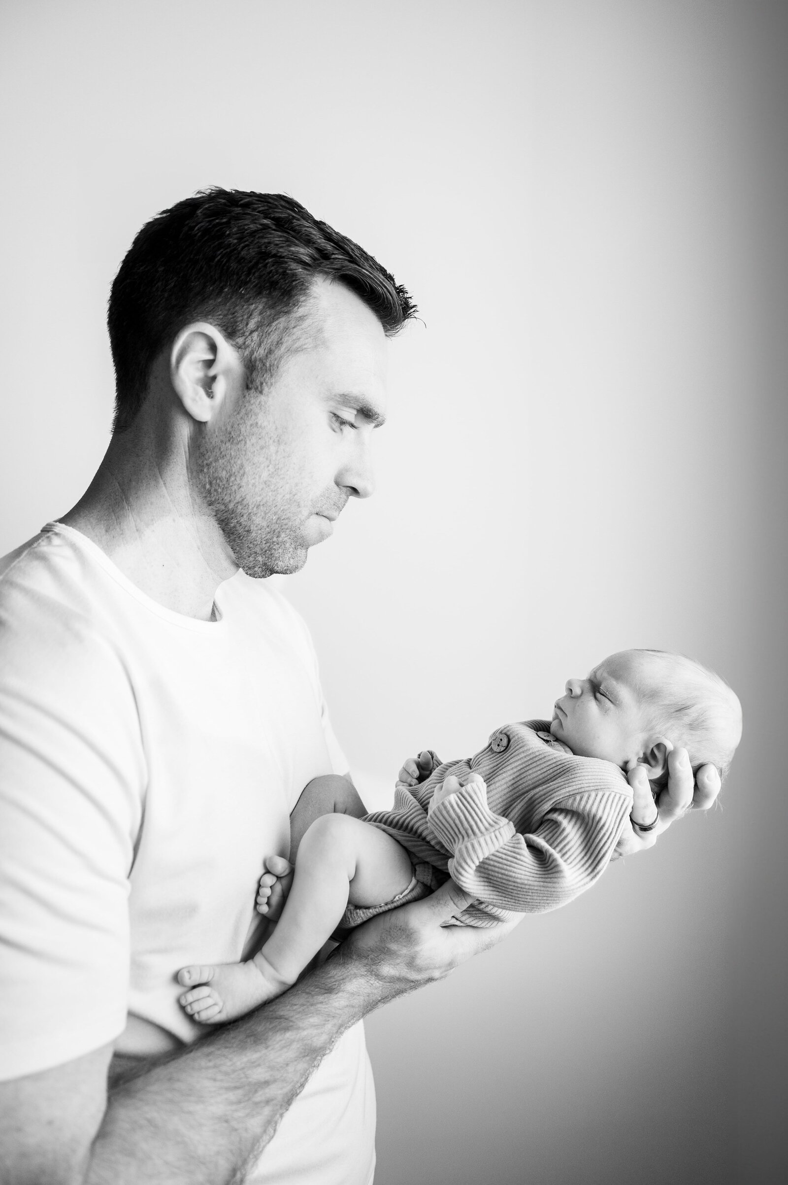 black and white photo of dad holding his newborn son