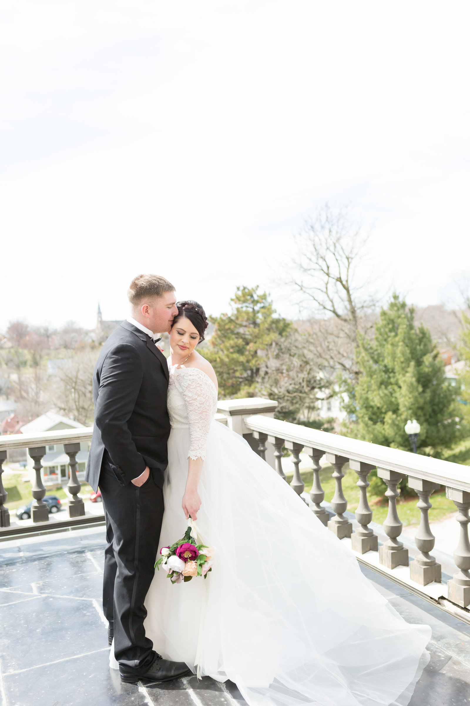 groom kisses bride on rooftop- Renwick Mansion