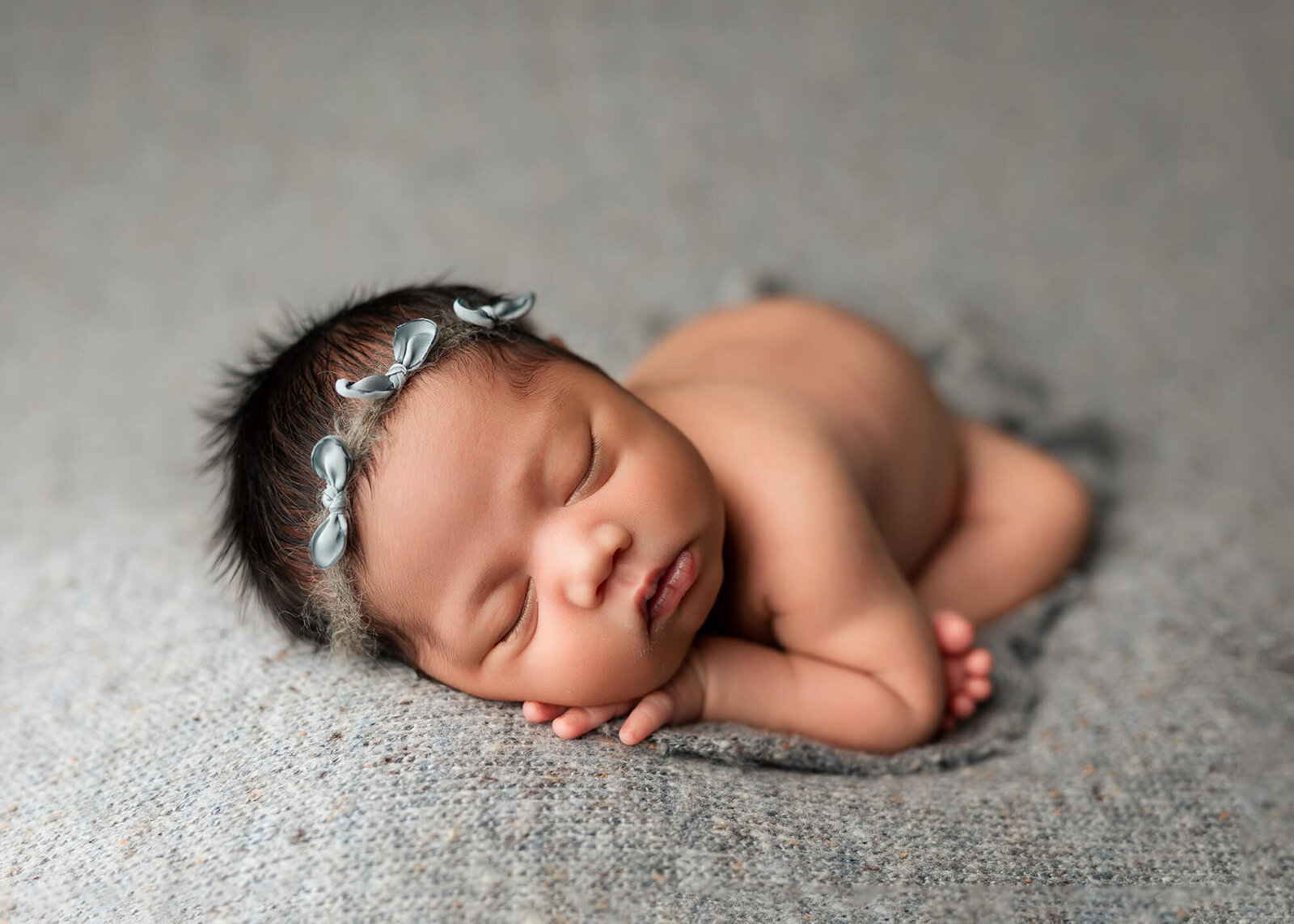 Baby girl posed in a basket during her newborn session with Jennifer Brandes Photography.