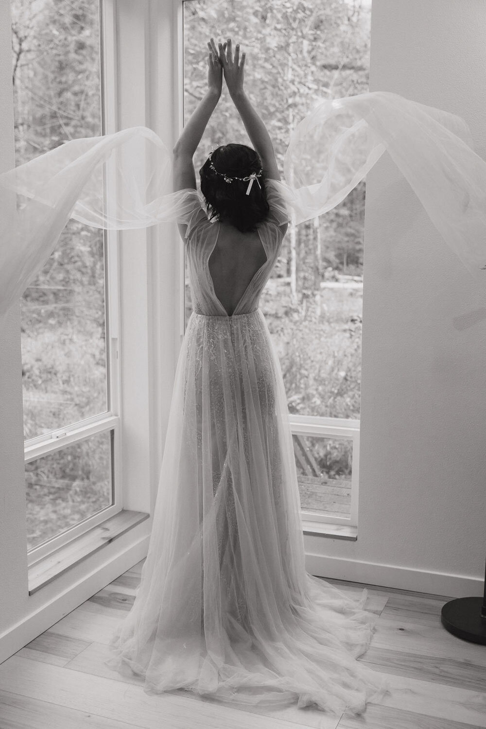 Bride twirling near large windows, veil flowing in the air