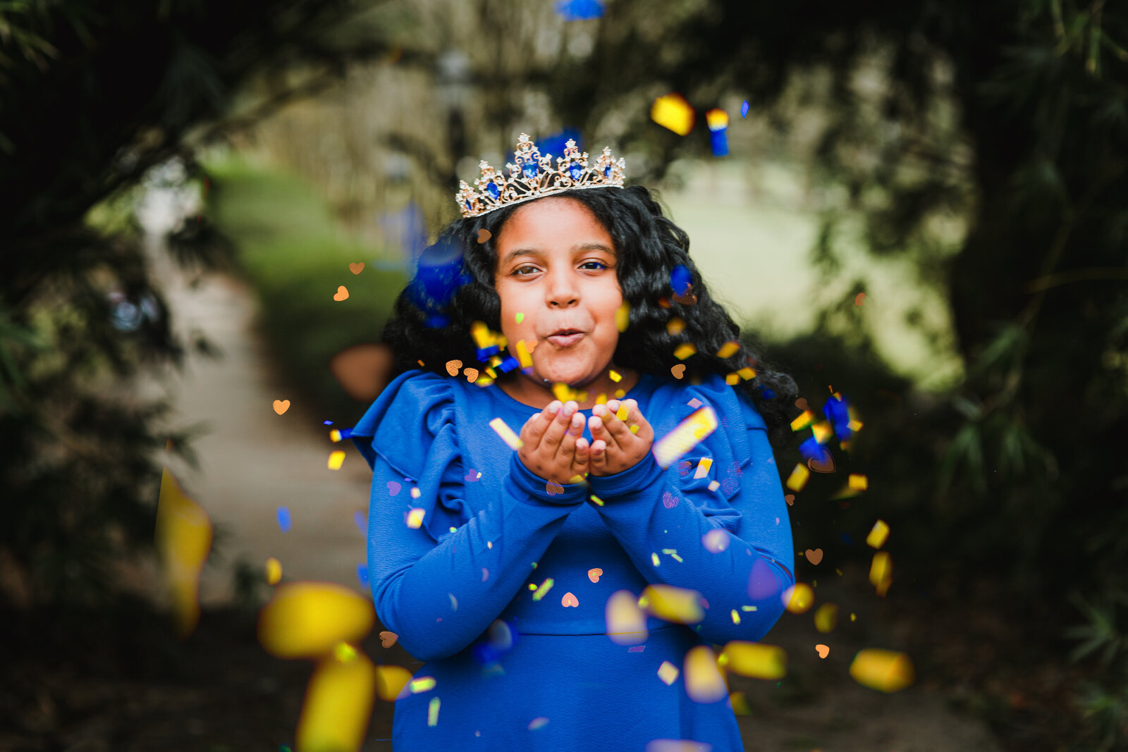 girl with crown blowing glitter