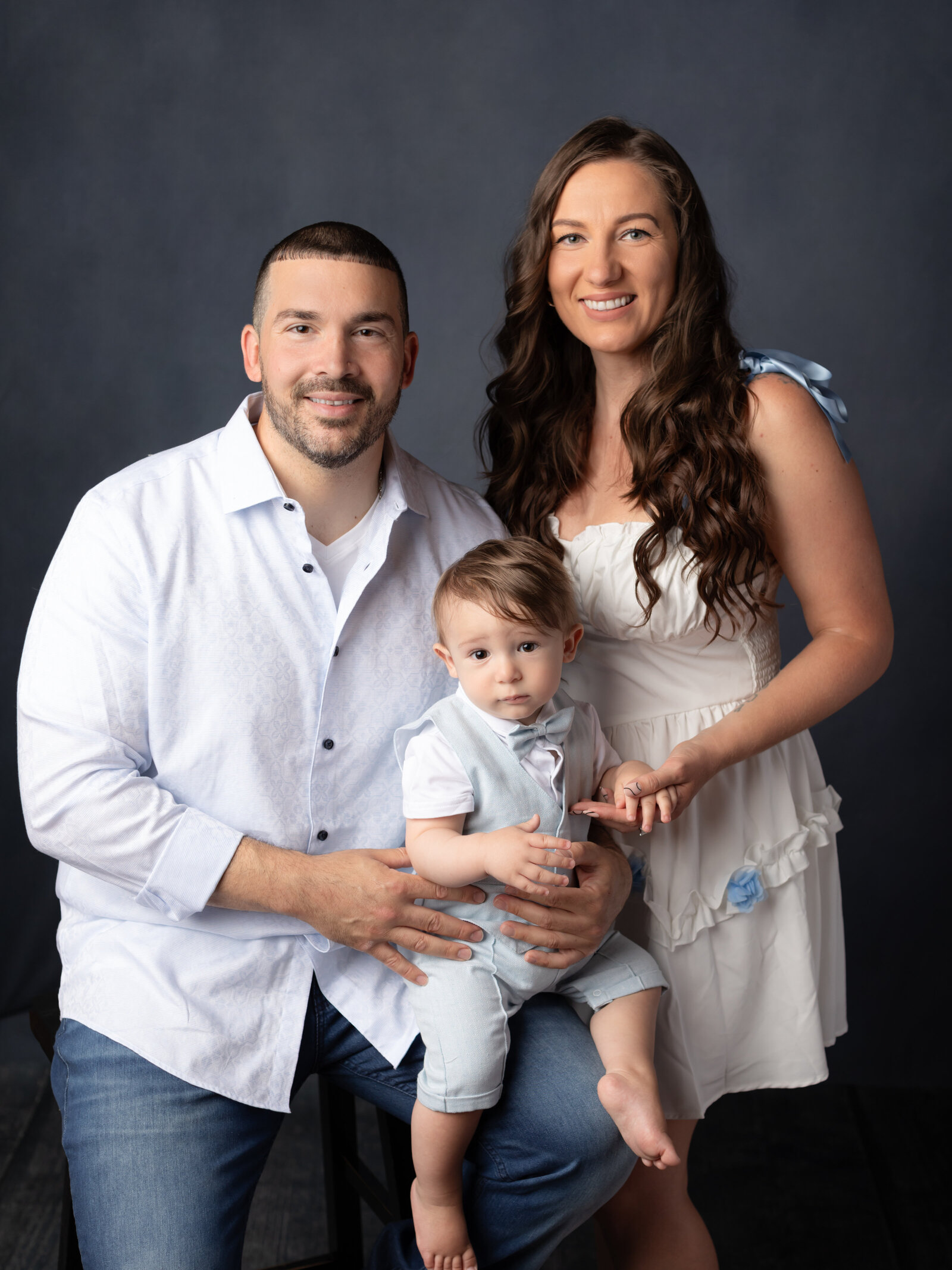 parents and one year old son posed for studio portraits 