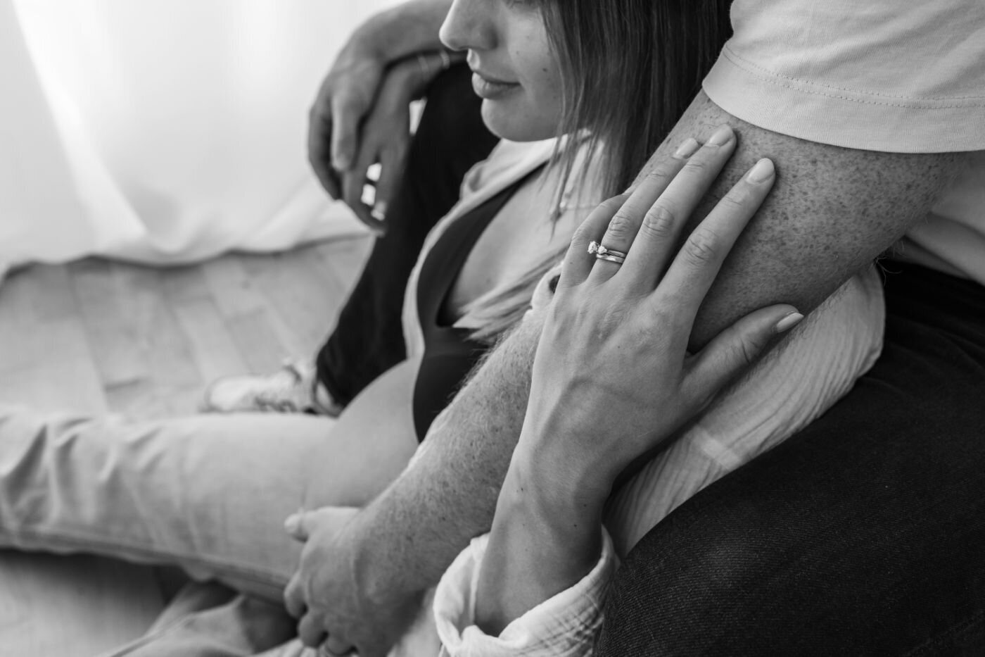 Black and white image of expecting couple's hands. Ruaa Hamdan.