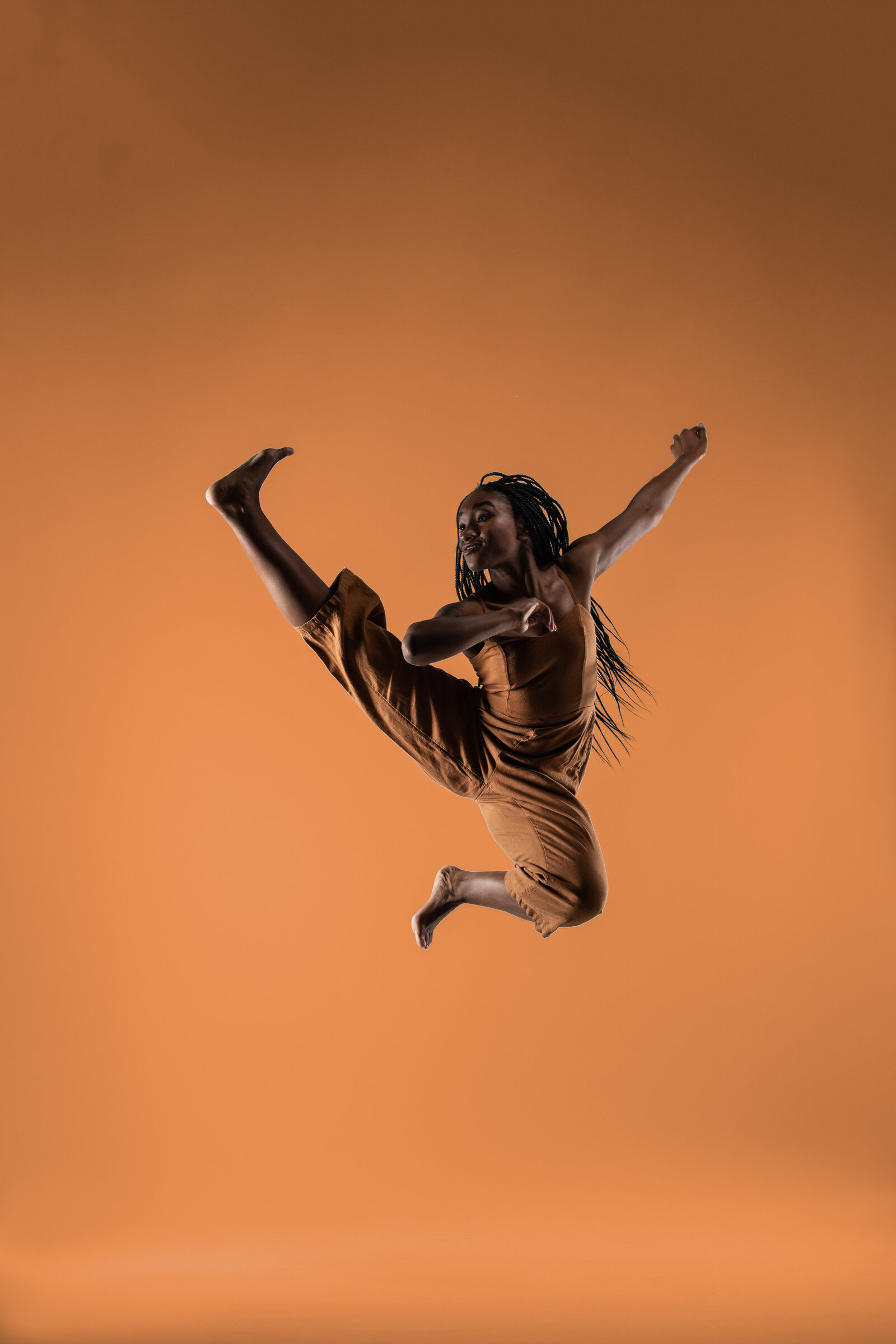 Female dancer jumping with bright background