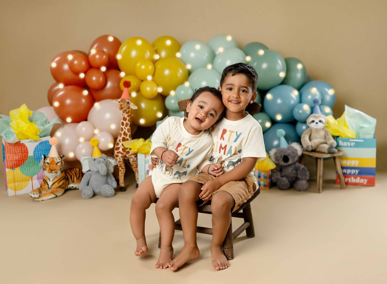 1 and 3 year old boys wearing matching party animal shirts taking birthday photos at Atlanta photo studio.