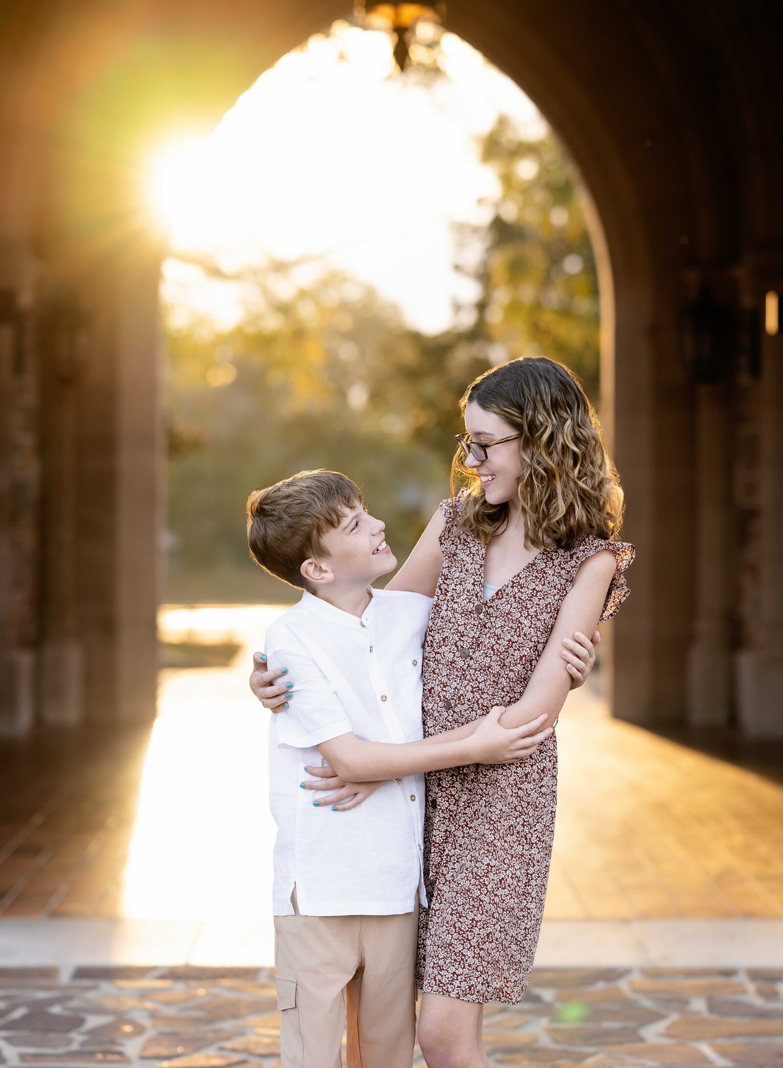 Siblings looking at each other under arches at Berry College. Rome photographer at Berry College - Jenni Nikki Photography.
