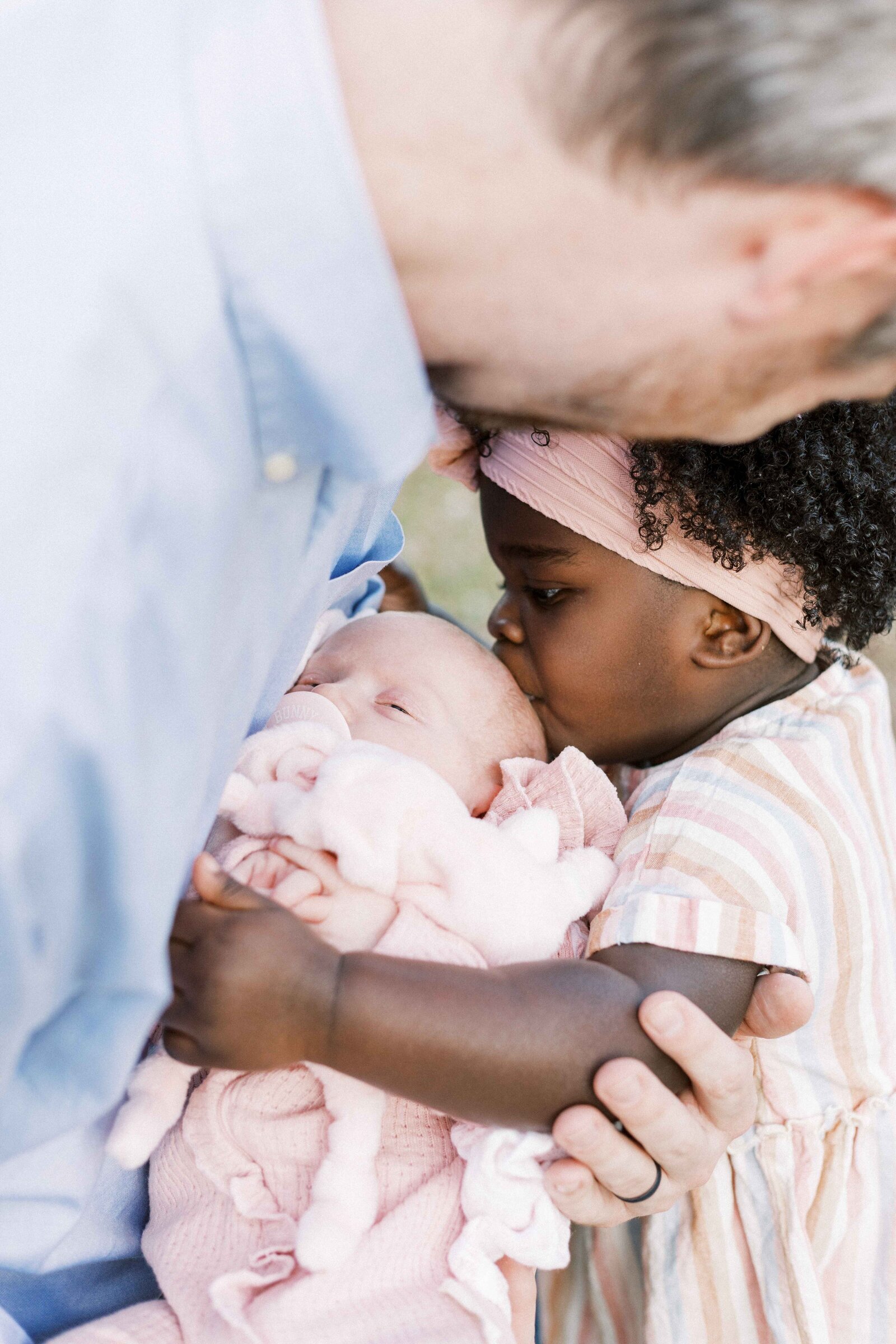 dad and daughter kissing newborn baby in peoria illinois newborn photos 
