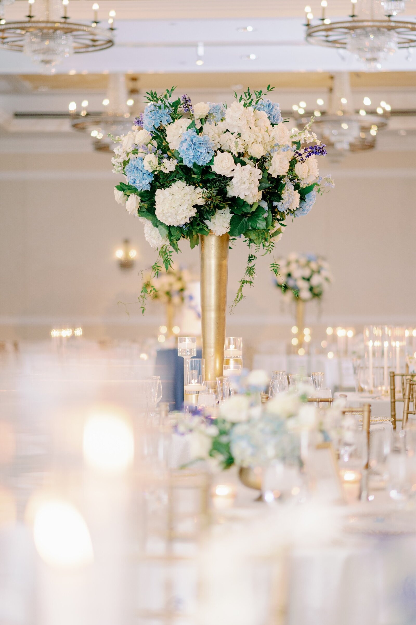 blue and white flowers in a gold vase