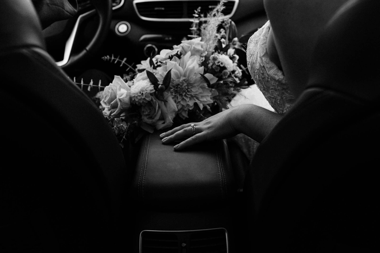 Intimate moment of bride holding flowers in the car.