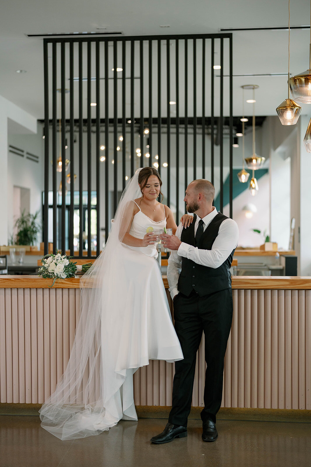 Bride and groom sharing a celebratory toast at their modern Chicago wedding reception, captured in an editorial and emotive style.