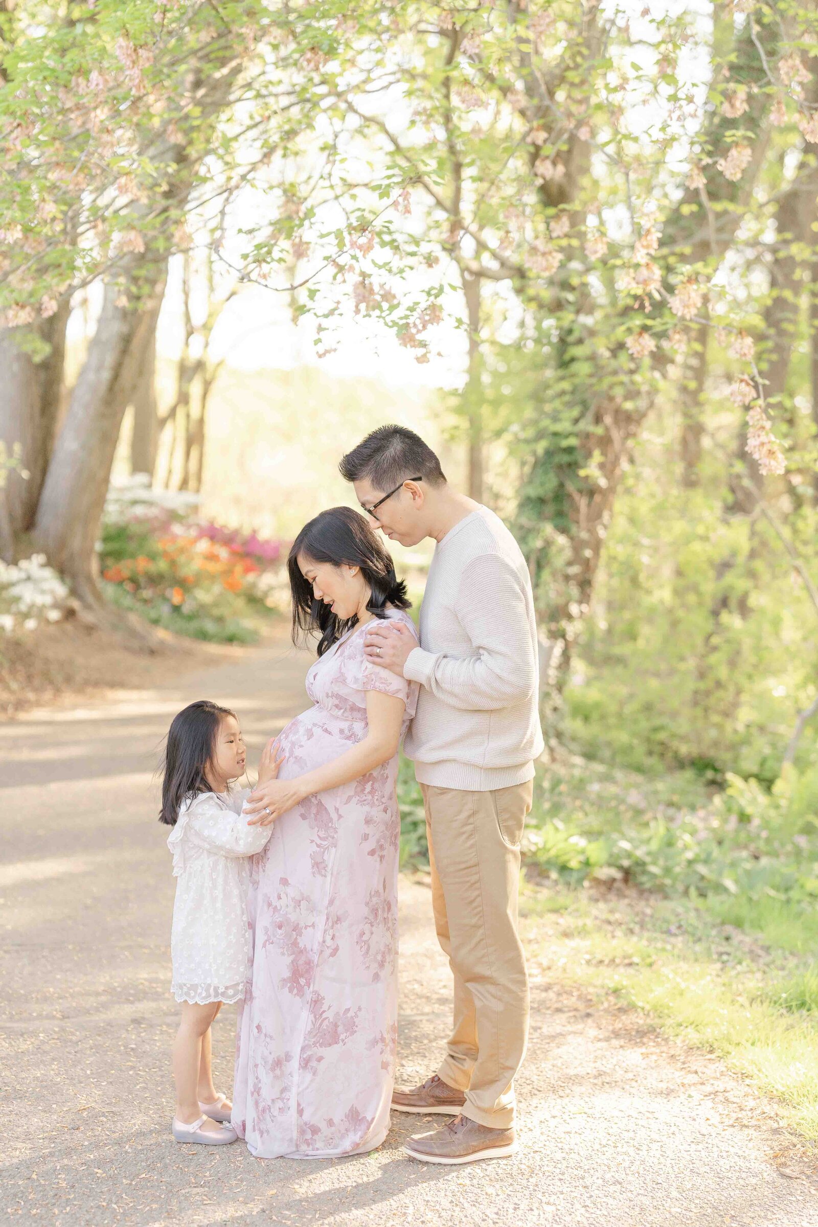 big sister touch mom’s belly during outdoor maternity session in Ashburn, Virginia