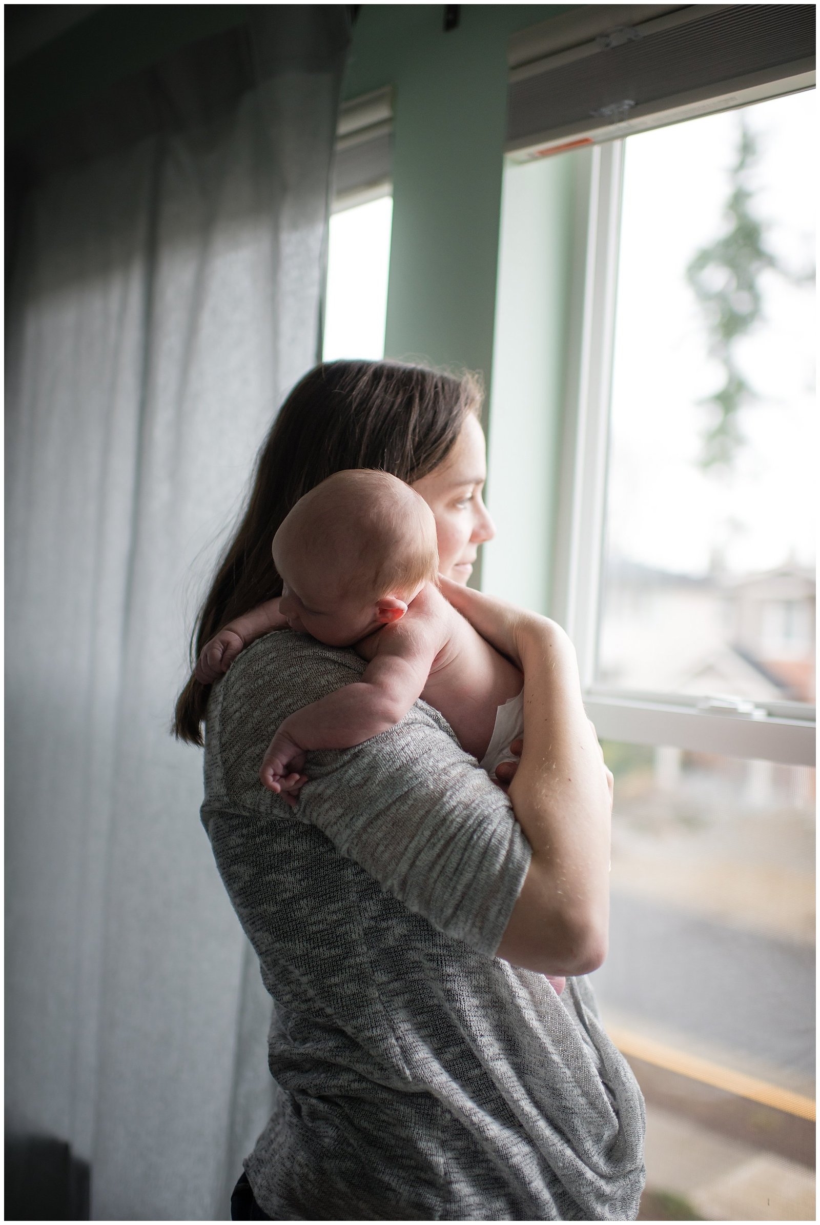 Mom and newborn baby looking out the window Emily Ann Photography Seattle Area Photographer