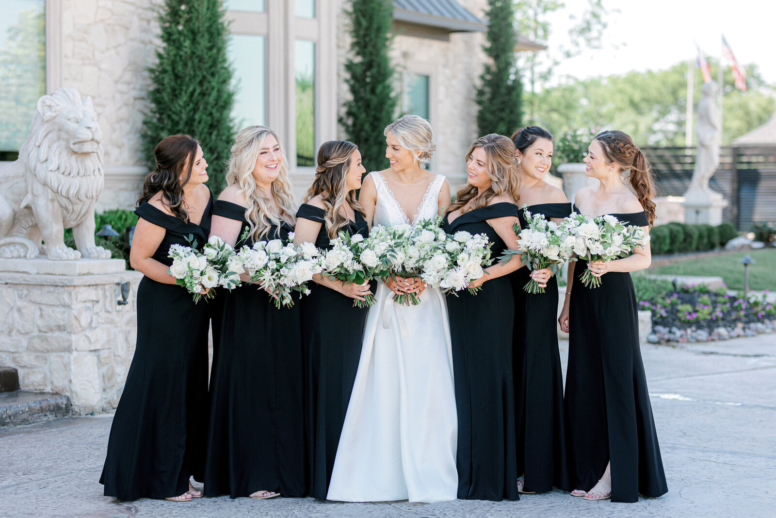 bride and bridesmaids outside smiling at each other