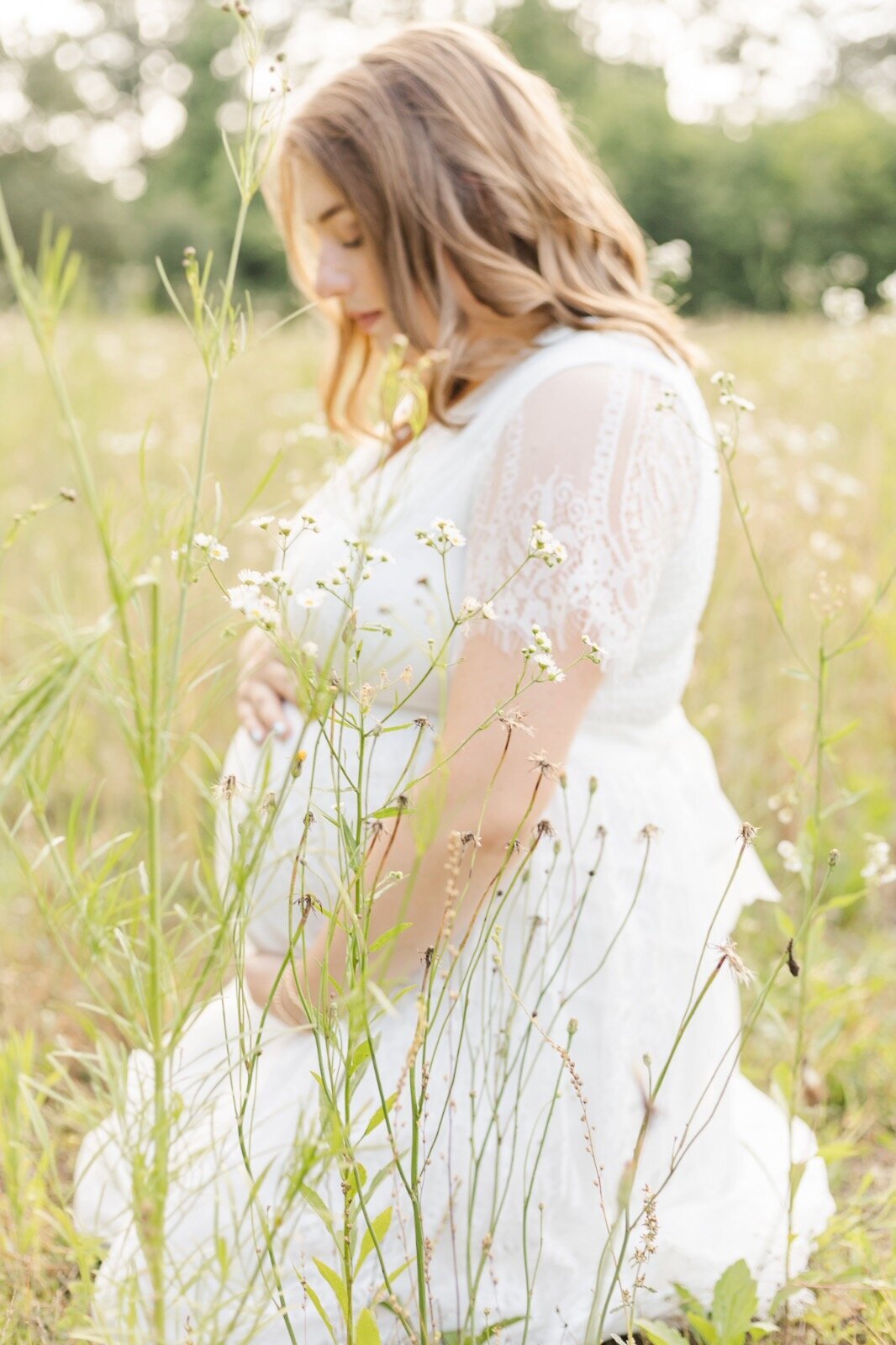 Pregnant woman kneeling in the grass