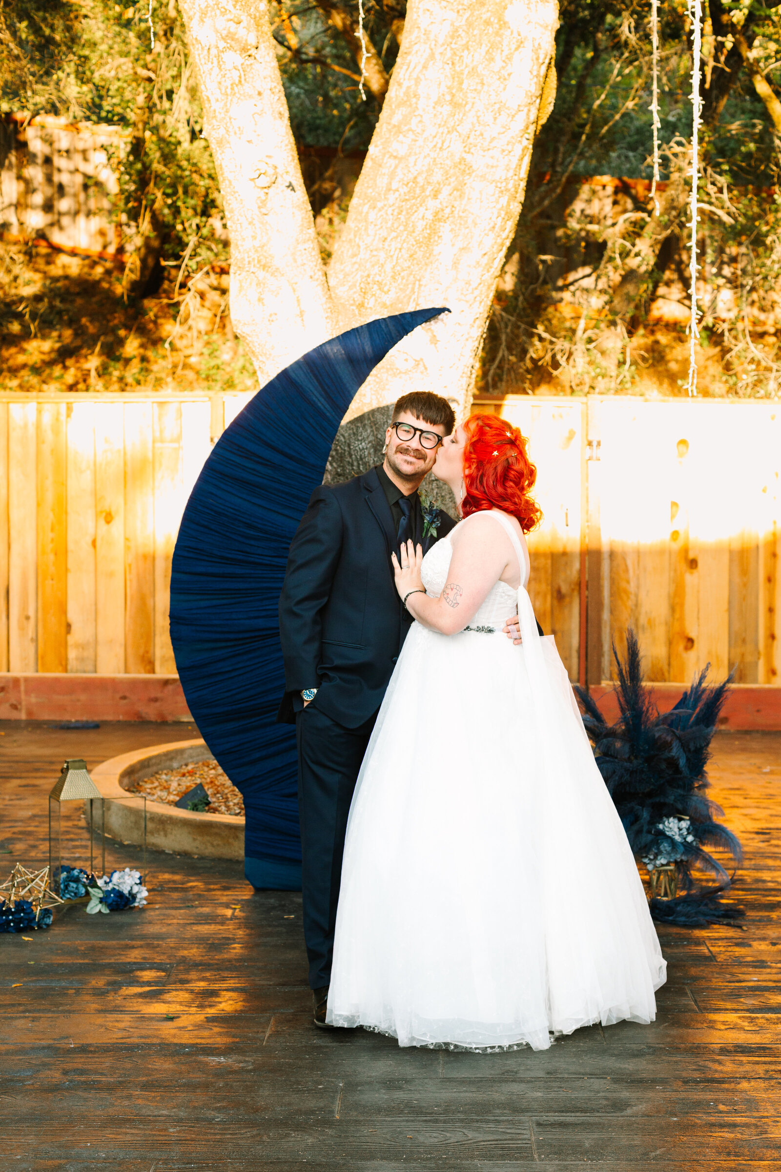 A night under the stars themed wedding, with a moon cutout. A newlywed bride and groom.