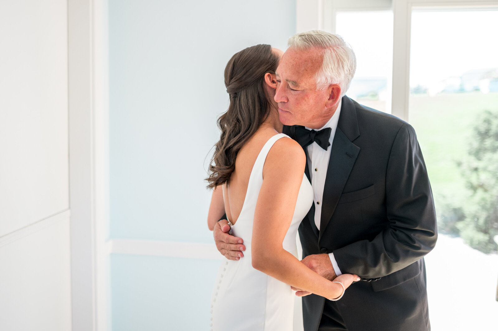 Emotional father embraces bride during their first look before ceremony during bright and airy Cape Cod wedding — captured by Sarah Surette Photography.