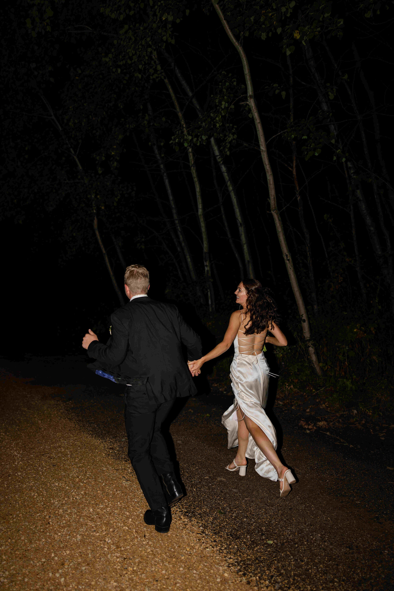 bride and groom running off into the night
