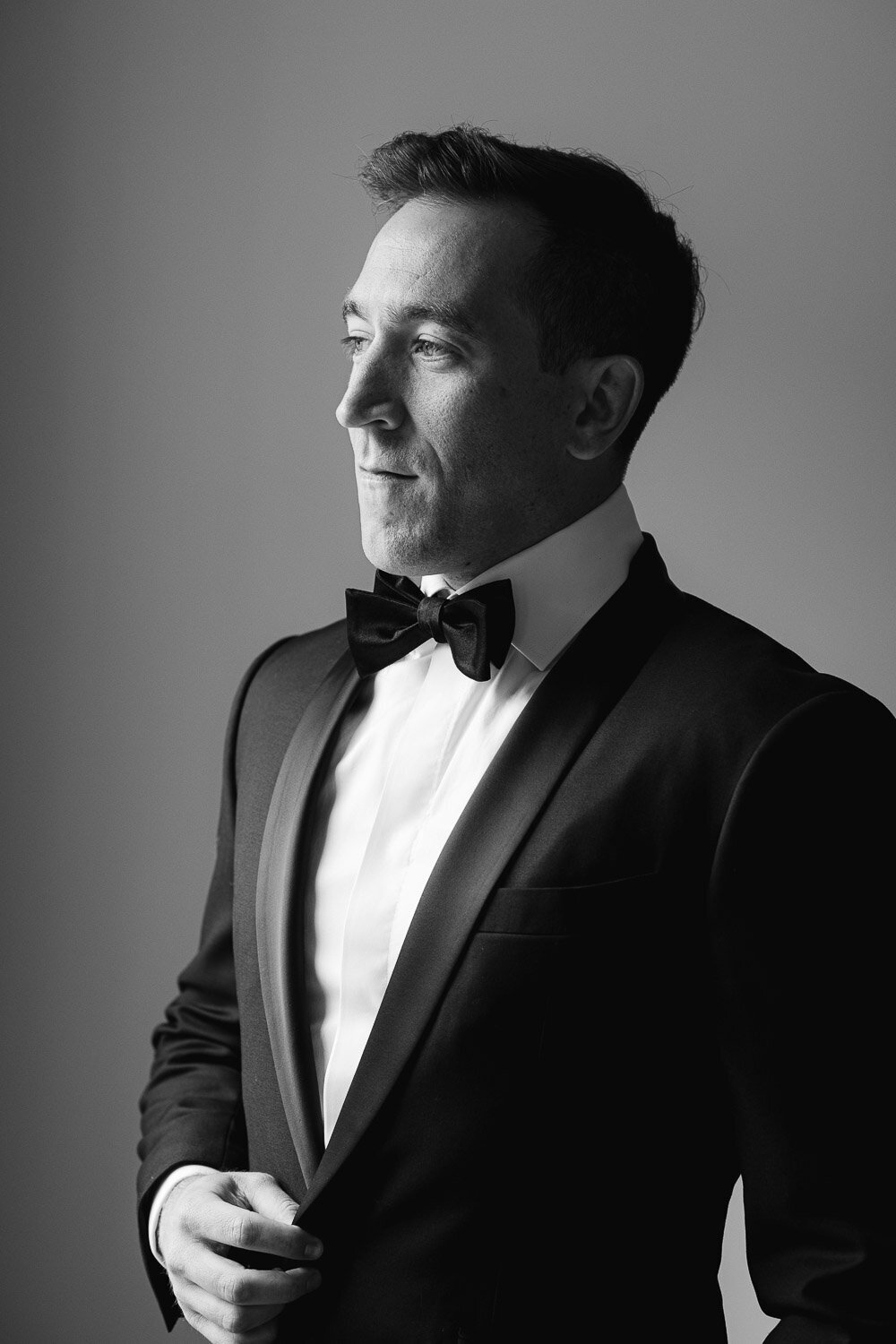 dramatic window portrait of groom