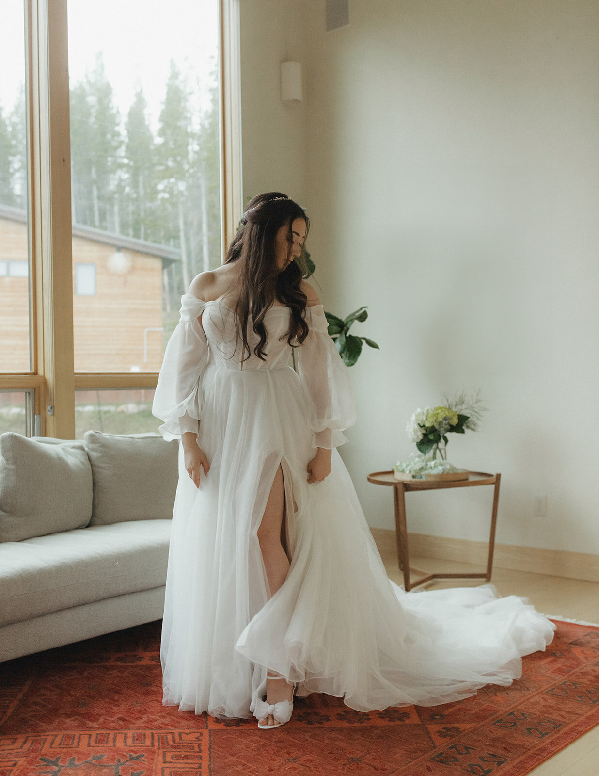 Bride wearing and admiring her elegant gown in her preparation area