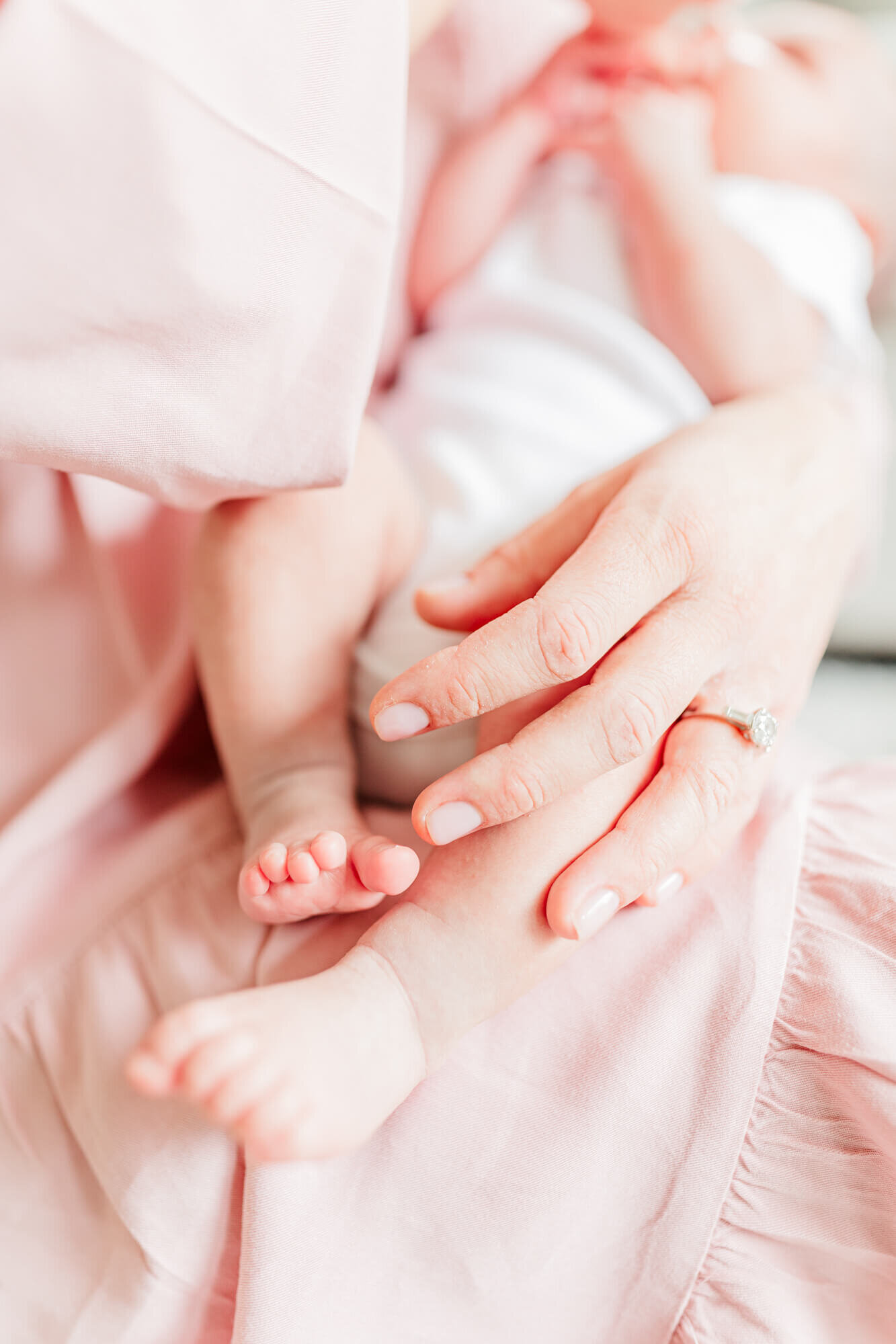 Close up image of baby's foot with mom's hand holding her leg