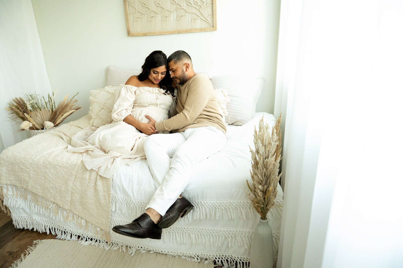 husband and wife in a maternity photography studio