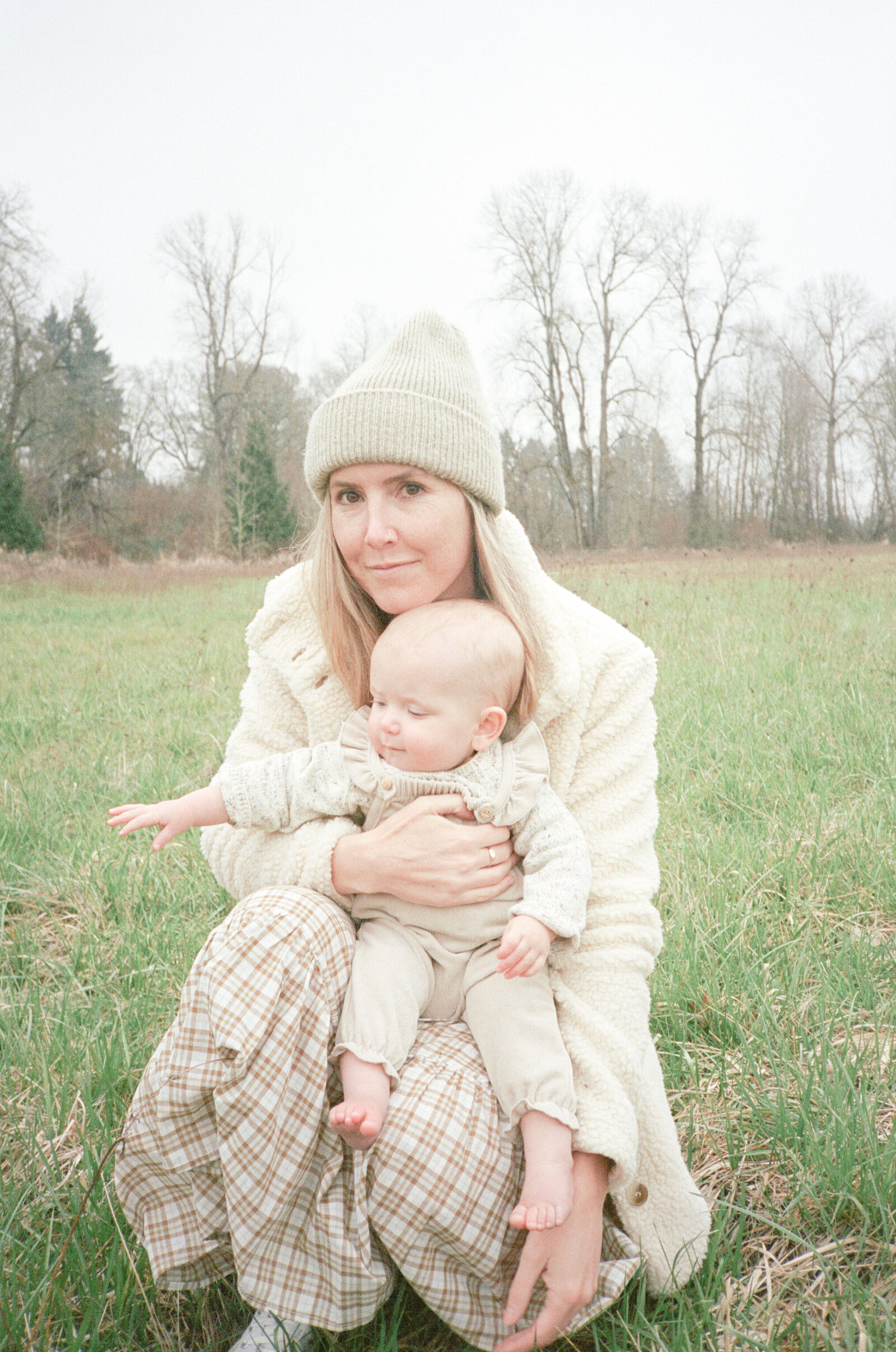 Mother embracing newborn child in an field on Sauvie Island.